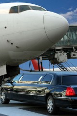 an airport limousine and a jetliner at an airport